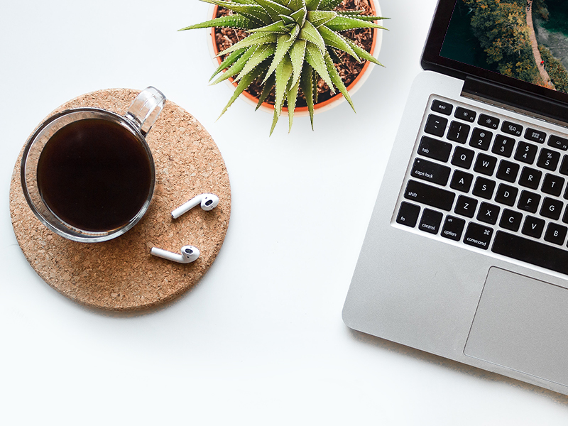 Coffee and laptop representing waiting for completed film order
